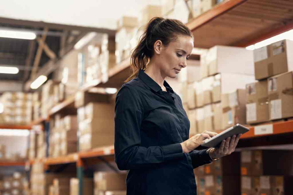 a woman tracking inventory in a warehouse